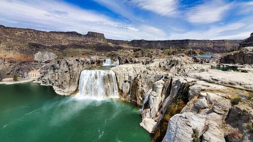 Shoshone Falls Reservoir in Twin Falls, Idaho. Wide angle view of the water flowing over the stone cliffs with a view of the dam and table rocks in the background.