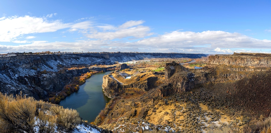 Un cañón con río, acantilados rocosos y vegetación escasa.