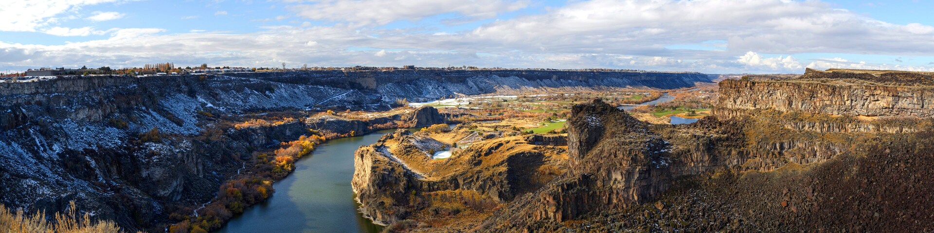 Un cañón con río, acantilados rocosos y vegetación escasa.