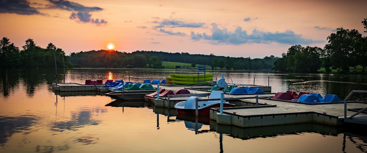Paddle boats and kayaks docked at Jacobson Park Lake marina in Lexington, Kentucky during sunrise early morning hours