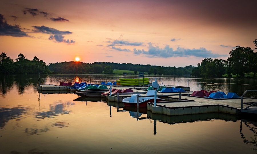 Paddle boats and kayaks docked at Jacobson Park Lake marina in Lexington, Kentucky during sunrise early morning hours