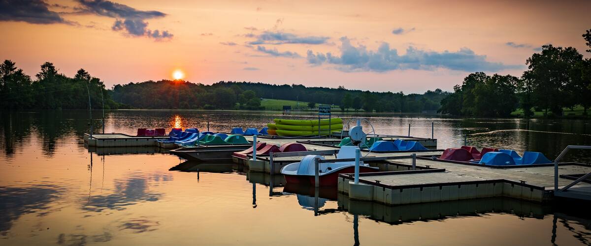 Paddle boats and kayaks docked at Jacobson Park Lake marina in Lexington, Kentucky during sunrise early morning hours