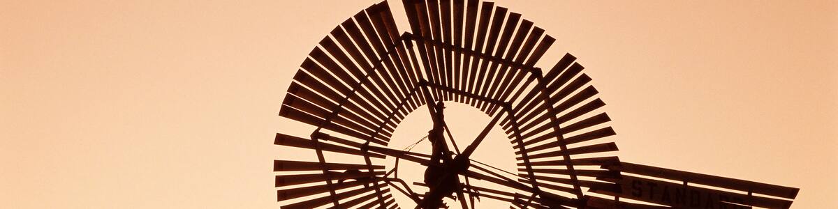 Top of windmill against pale orange sky