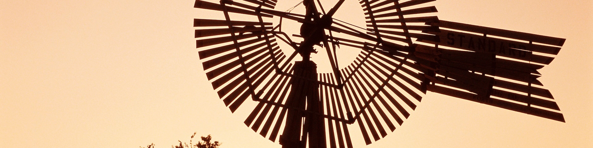 Top of windmill against pale orange sky