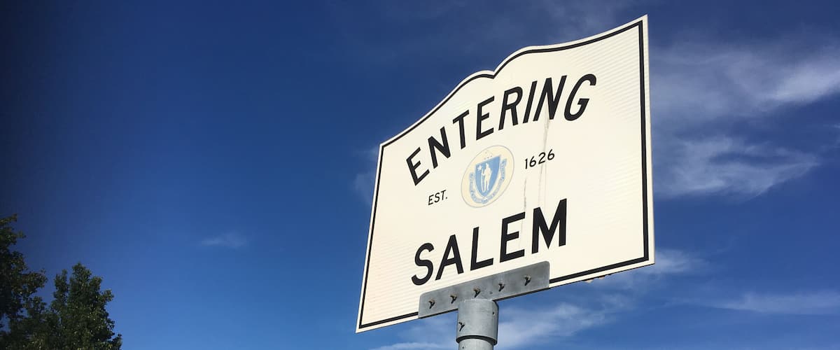 A cemetery with headstones and a sign that reads "ENTERING SALEM EST. 1626".