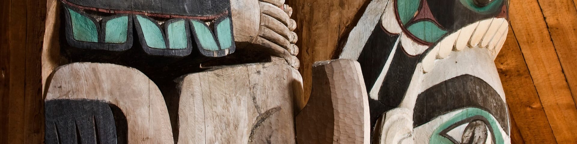 USA, Alaska, Kasaan. Close-up of human and animal figures on totem poles in Indian longhouse.