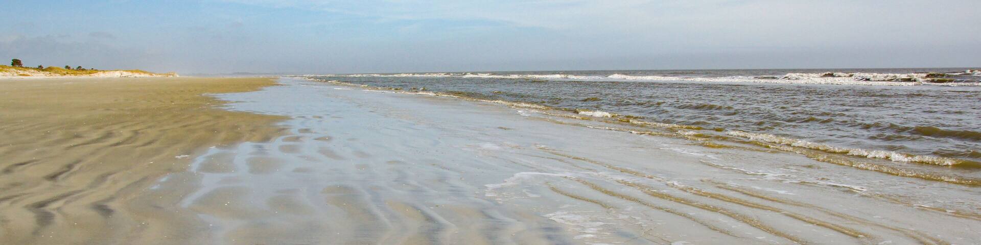 A beach without any people. The gentle waves roll in on the rippled sand on Sapelo Island, SC.
