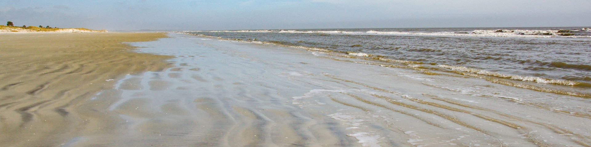 A beach without any people. The gentle waves roll in on the rippled sand on Sapelo Island, SC.