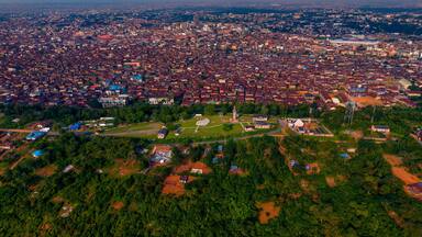Aerial view of the city's buildings contrasting with the lush green vegetation and the iconic Bower's Tower standing tall, Ibadan, Oyo, Nigeria.