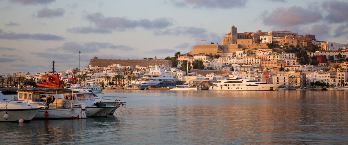 Ibiza which includes a bay or harbor, a coastal town and a sunset