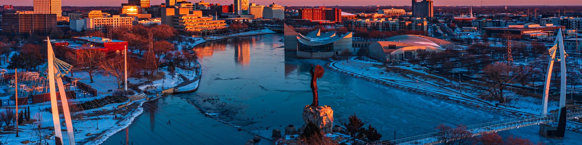 A cityscape with a river, a bridge, and modern buildings.