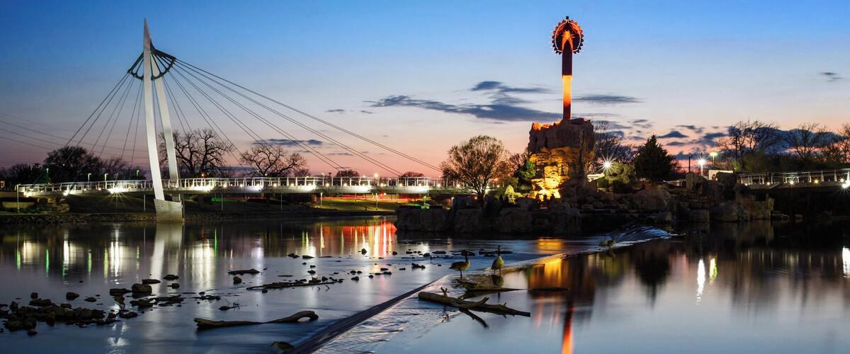 The Keeper of the Plains is a 44-foot tall steel sculpture standing at the point where the Big and Little Arkansas rivers join together in downtown Wichita. This land between the two rivers is sacred ground to the Native American people and is also home to the Mid-America All-Indian Center. The Indian Warrior sculpture was created by Wichitan and Native American artist Blackbear Bosin (1921-1980).
Come in time for the sunsets to enjoy the view along the eastern shore of the Arkansas River. 
#Wichita #Kansas #Sunset #Reflections