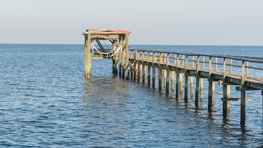 Fishing piers stretching out over Galveston Bay in Kemah, Texas, USA. Foot pier for saltwater fishing of vacation home/beach house rental/bay home in Lighthouse District waterfront at sunset. Panorama