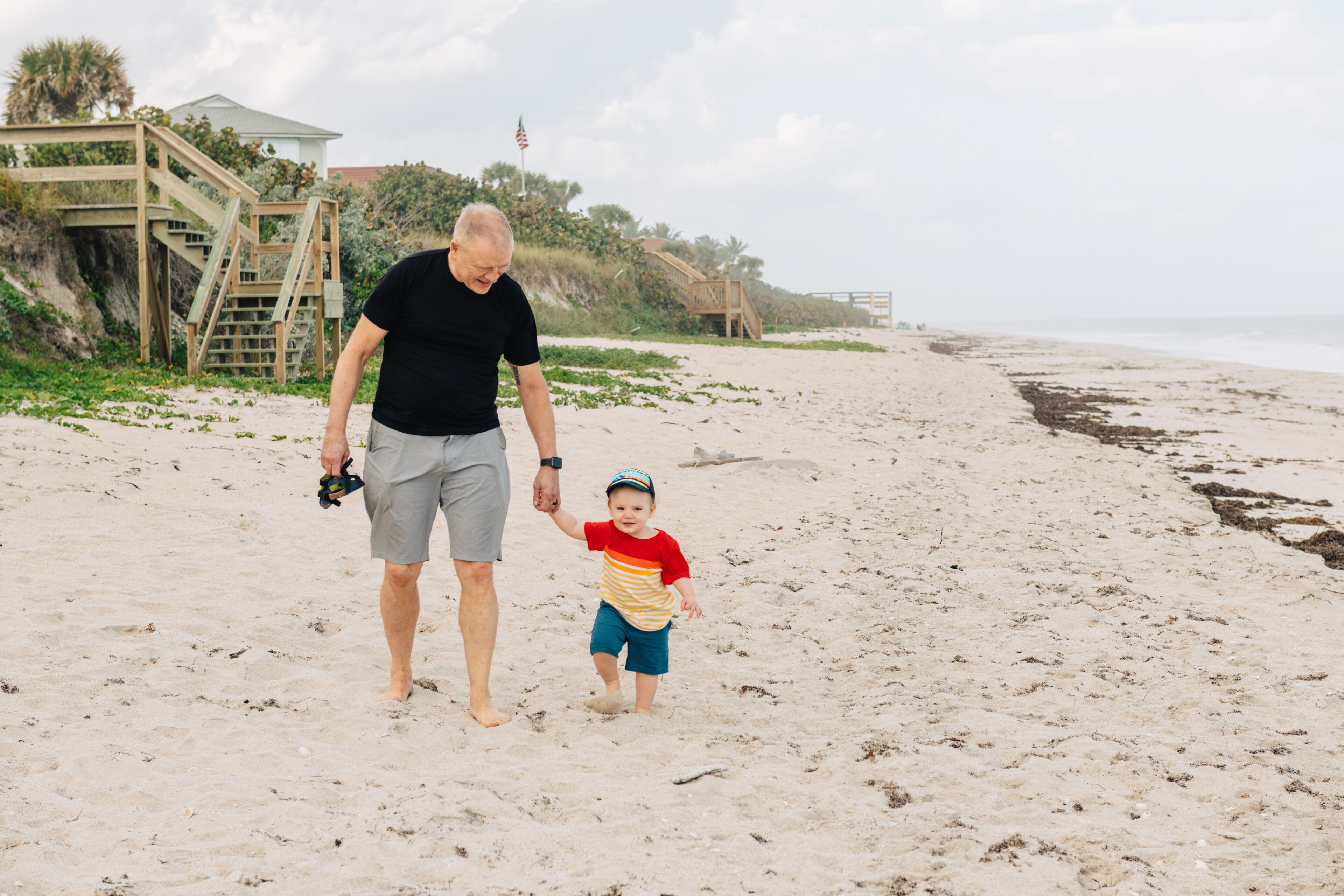 Grandad and grandson walking on the beach