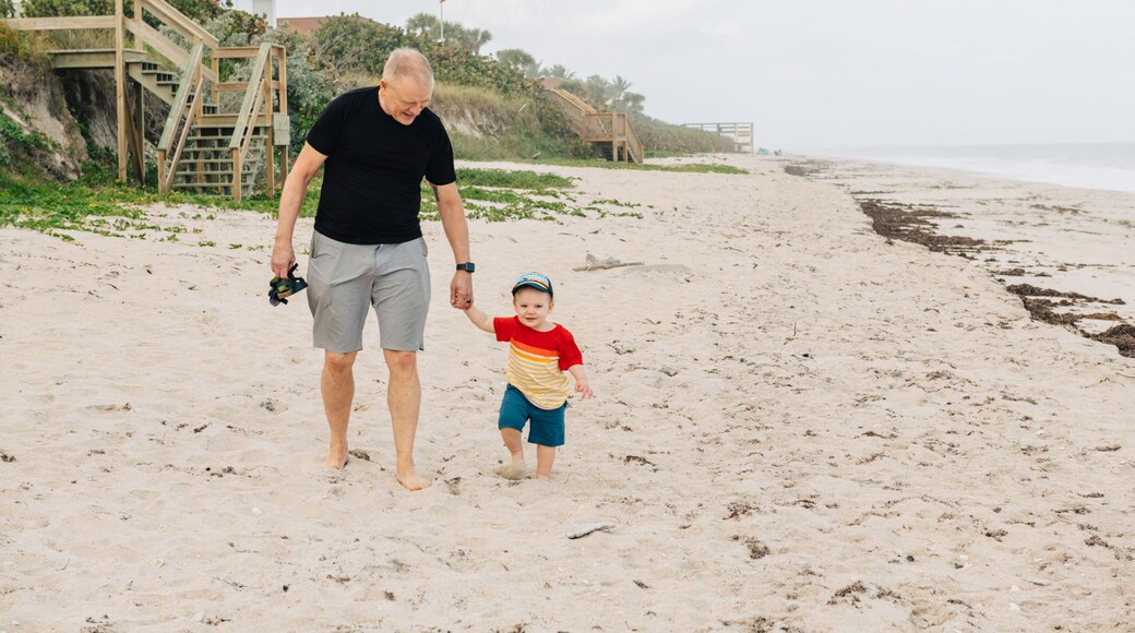 Grandad and grandson walking on the beach
