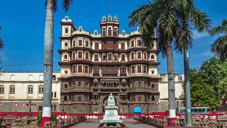 A large, ornate building with multiple balconies and a central statue.