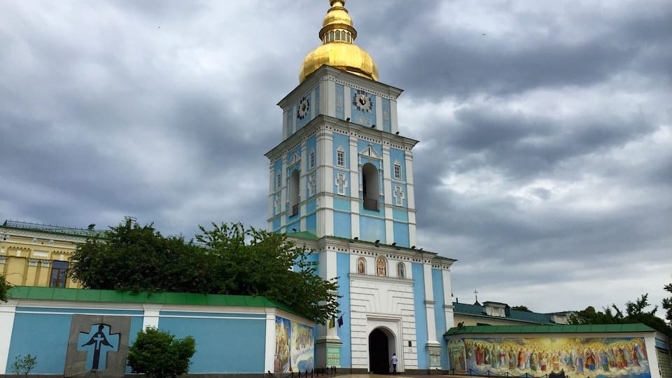 A church with a golden dome and blue walls.