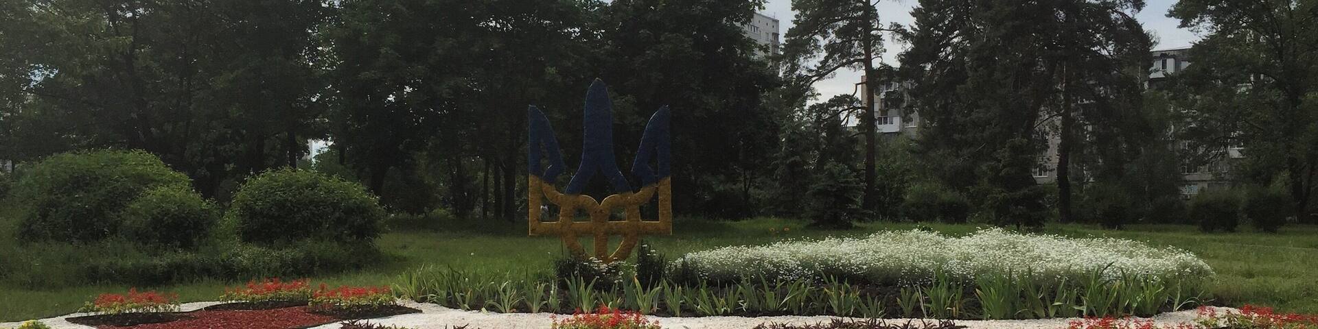 A landscaped garden with geometric flower beds and a central sculpture.