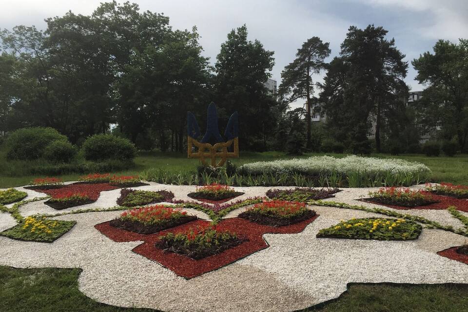 A landscaped garden with geometric flower beds and a central sculpture.