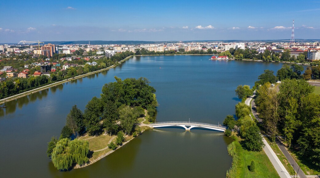 Big public lake and an island in the center of Ivano-Frankovsk city aerial view.
