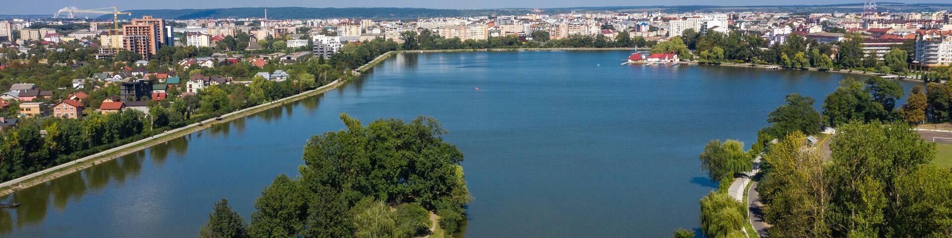 Big public lake and an island in the center of Ivano-Frankovsk city aerial view.
