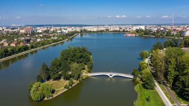 Une rivière traversée par un pont, entourée de verdure et de bâtiments urbains.