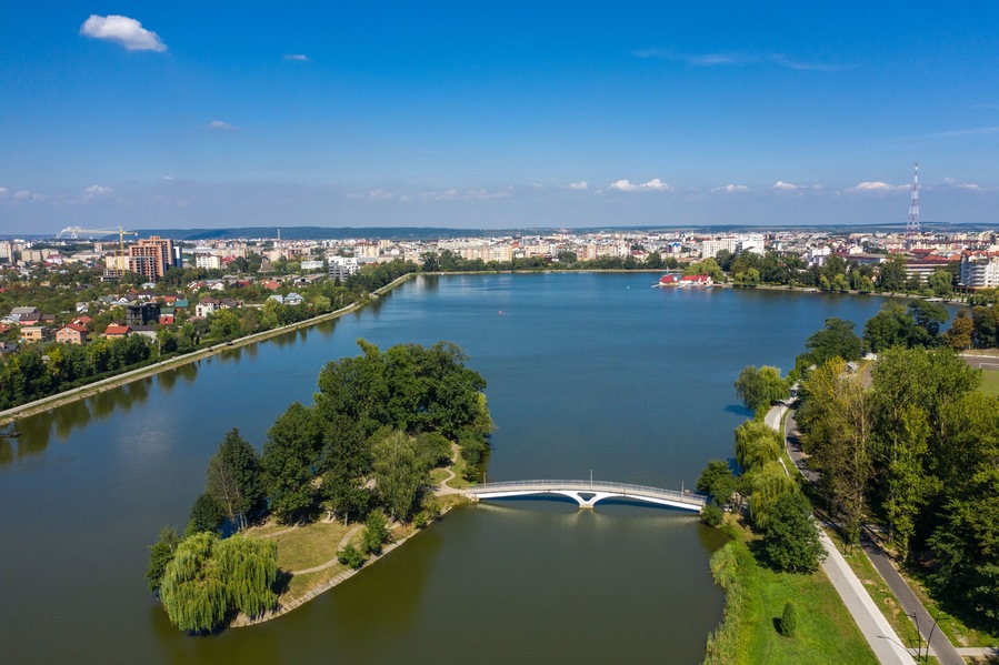 Big public lake and an island in the center of Ivano-Frankovsk city aerial view.