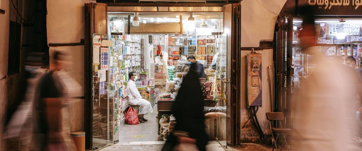 A pharmacy with Arabic signage and shelves stocked with various products.