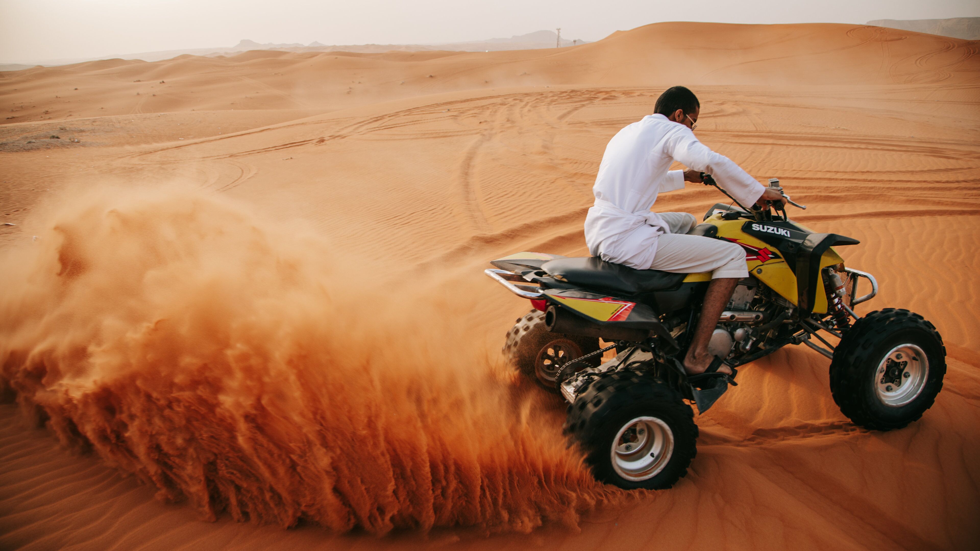 Saudi Arabia which includes desert views and motorbike riding as well as an individual male