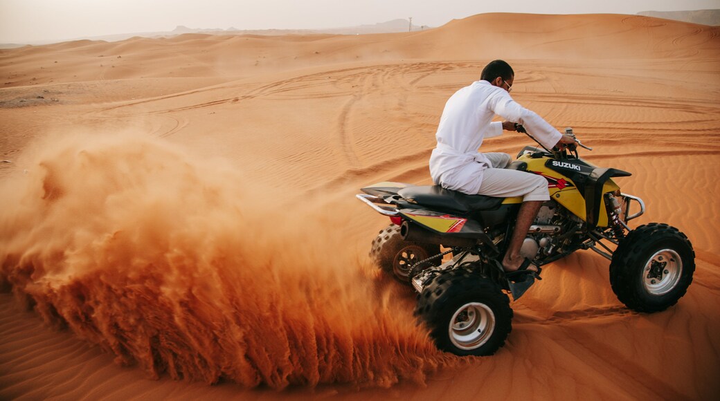 Saudi Arabia which includes desert views and motorbike riding as well as an individual male