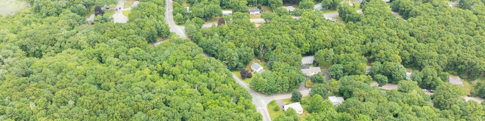 Aerial view of Suburban neighborhood in Sharon, Norfolk County, Massachusetts, with green forest and big villa.