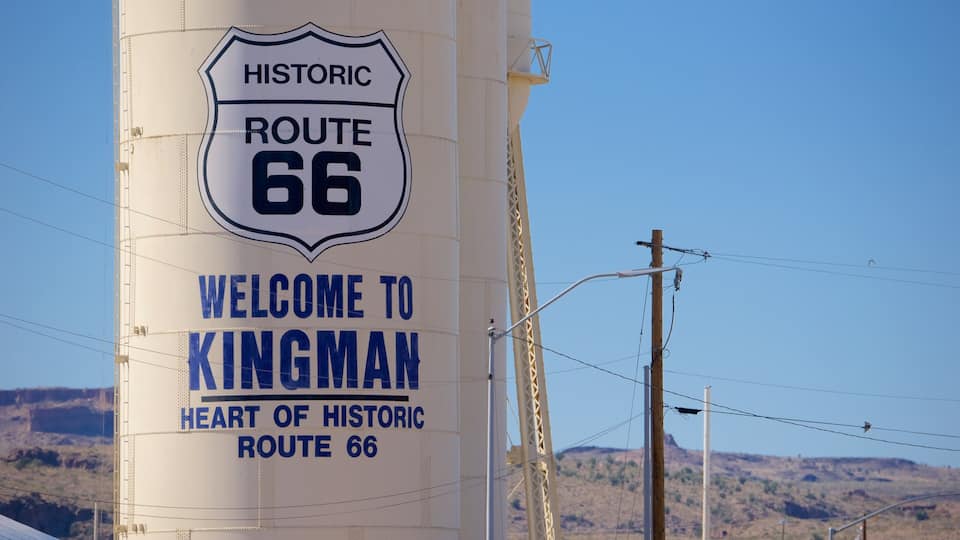 A large white sign with blue lettering that reads "Historic Route 66 Welcome to Kingman Heart of Historic Route 66."