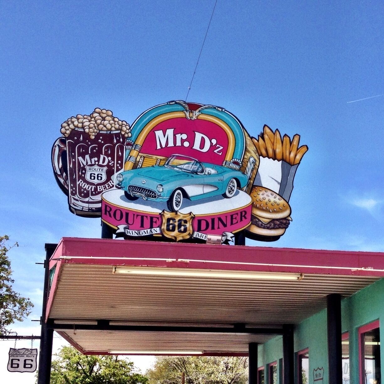A Route 66 diner sign with a car, a beer mug, and fries.