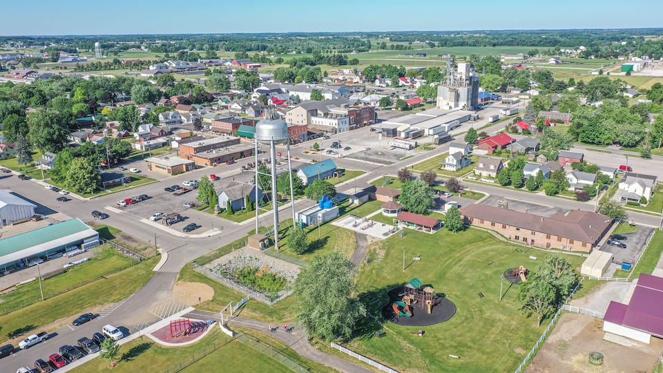 An aerial view of a town with a large water tower, industrial buildings, and a playground.