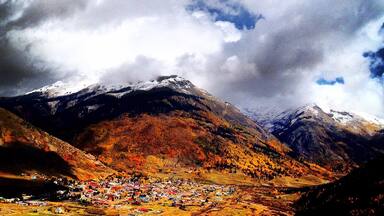 A mountainous landscape with a village in the valley.