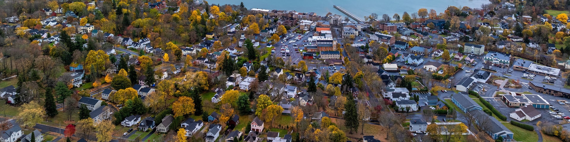A lake surrounded by autumn-colored trees and a residential area.