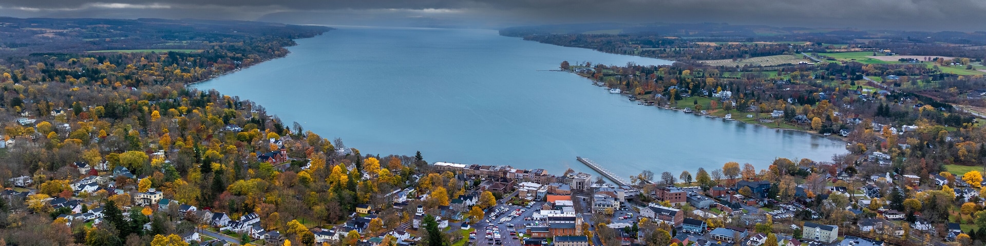 Un lago rodeado de árboles de colores otoñales y una zona residencial.
