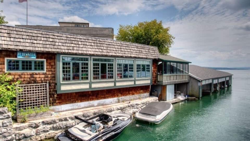 A waterfront building named "Bluewater" with a dock and a boat.