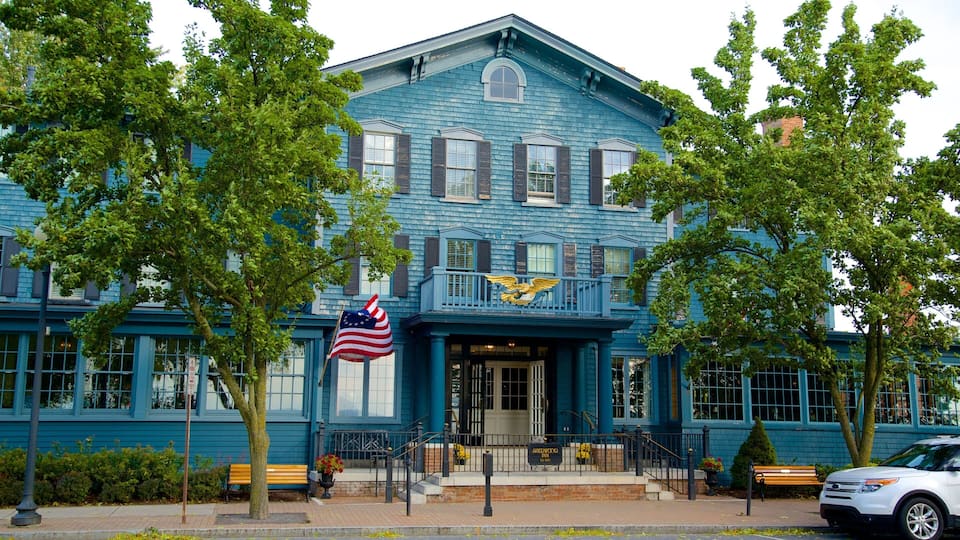 A historic building with a blue facade, a balcony with a golden eagle emblem, and an American flag.