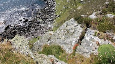A rocky coastline with a lighthouse on a cliff.