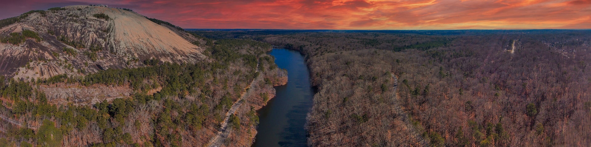 a majestic aerial panoramic shot of the running river and the vast miles of trees and mountain ranges at Stone Mountain Park in Stone Mountain Georgia USA