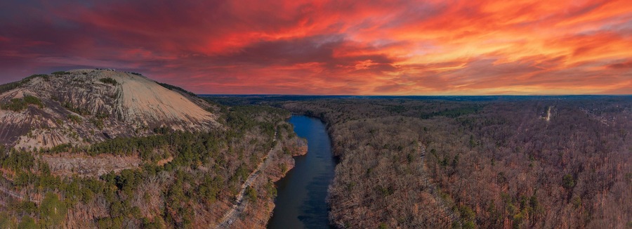 a majestic aerial panoramic shot of the running river and the vast miles of trees and mountain ranges at Stone Mountain Park in Stone Mountain Georgia USA