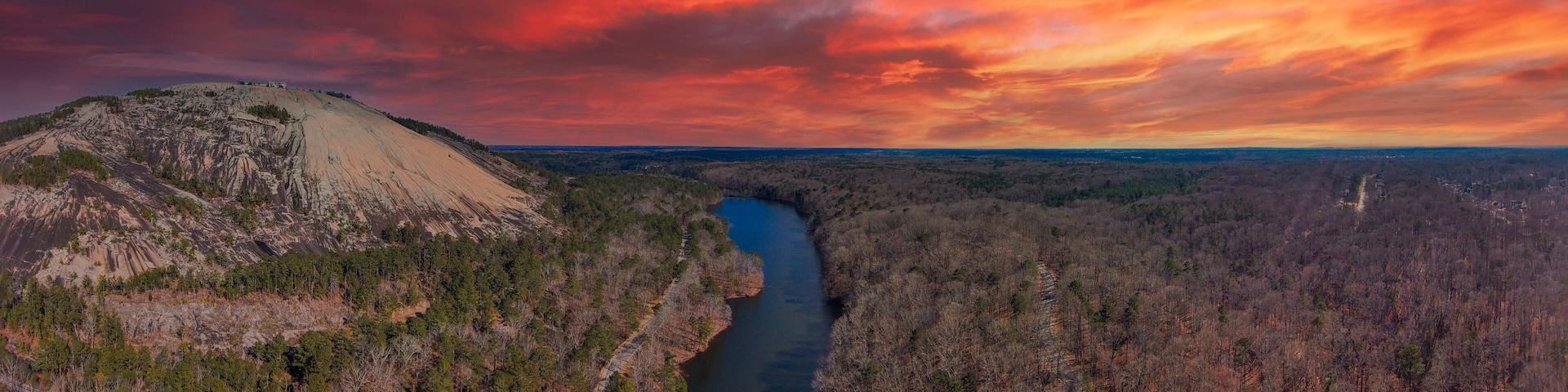 a majestic aerial panoramic shot of the running river and the vast miles of trees and mountain ranges at Stone Mountain Park in Stone Mountain Georgia USA