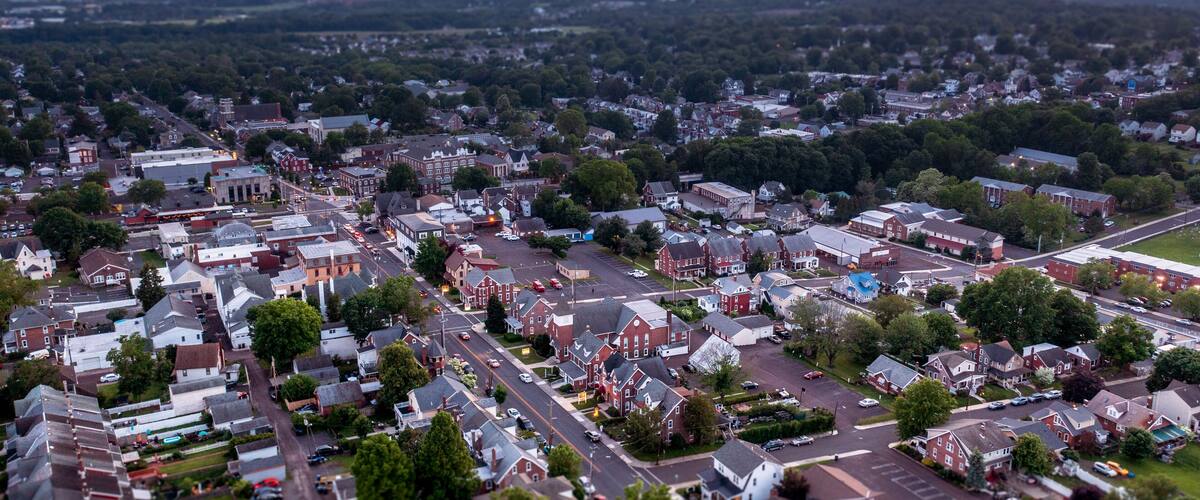 An aerial view of a suburban town with a mix of residential houses, a church, and a large parking lot.