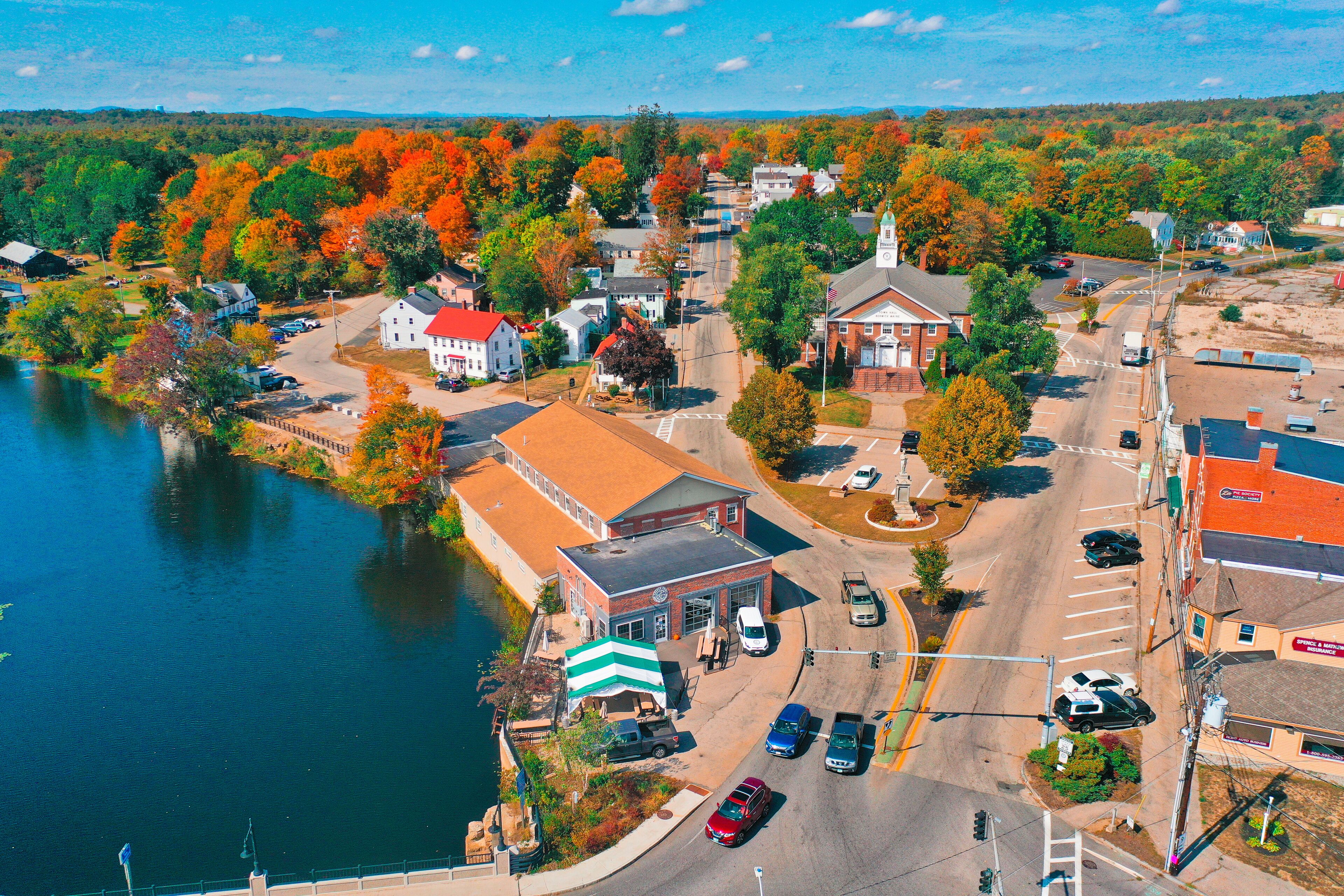 A lakeside town with autumn foliage, a church, and a small commercial area.