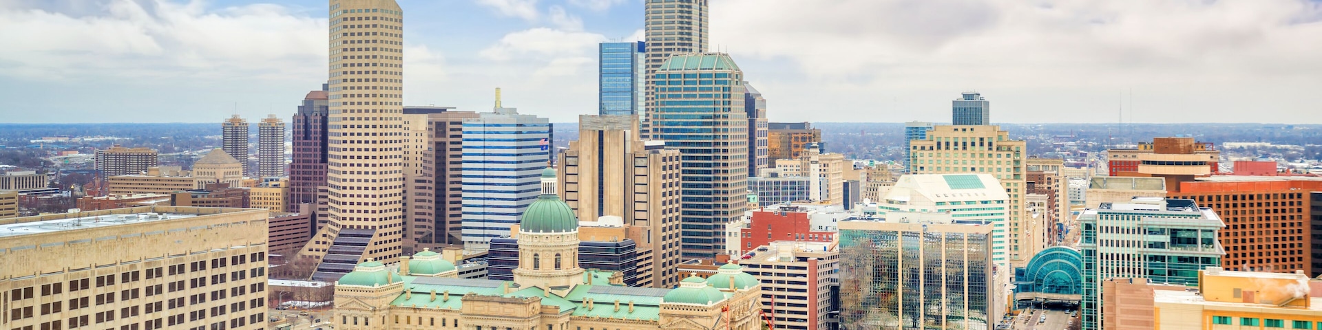 A cityscape with a mix of modern skyscrapers and historic buildings, including a prominent dome structure.