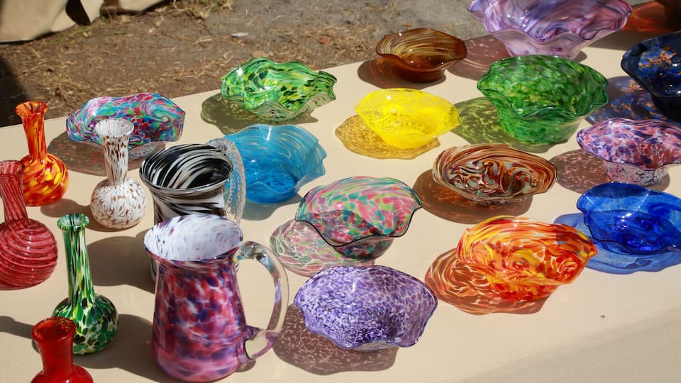 A collection of colorful glass vases and bowls on a table.