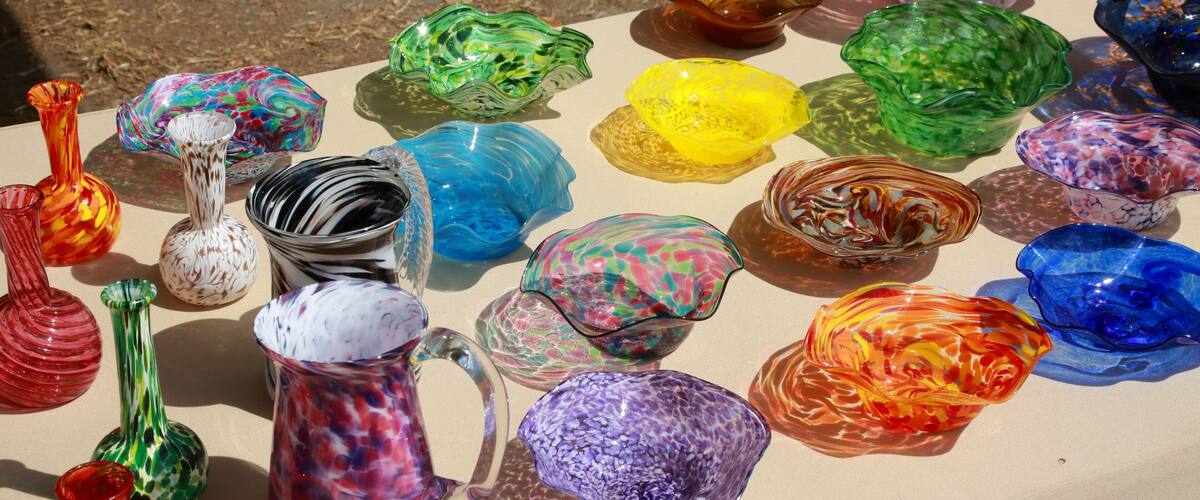 A collection of colorful glass vases and bowls on a table.