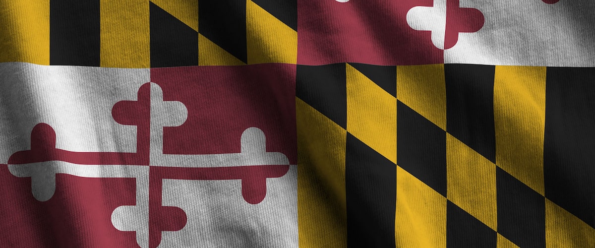 Maryland US state flag with big folds waving close up under the studio light indoors. The official symbols and colors in fabric banner
