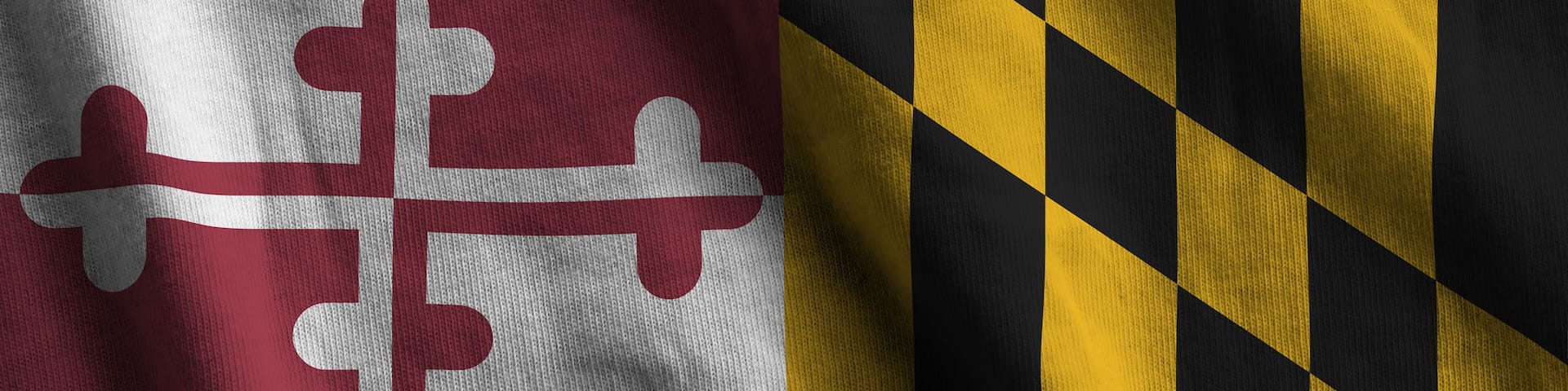 Maryland US state flag with big folds waving close up under the studio light indoors. The official symbols and colors in fabric banner